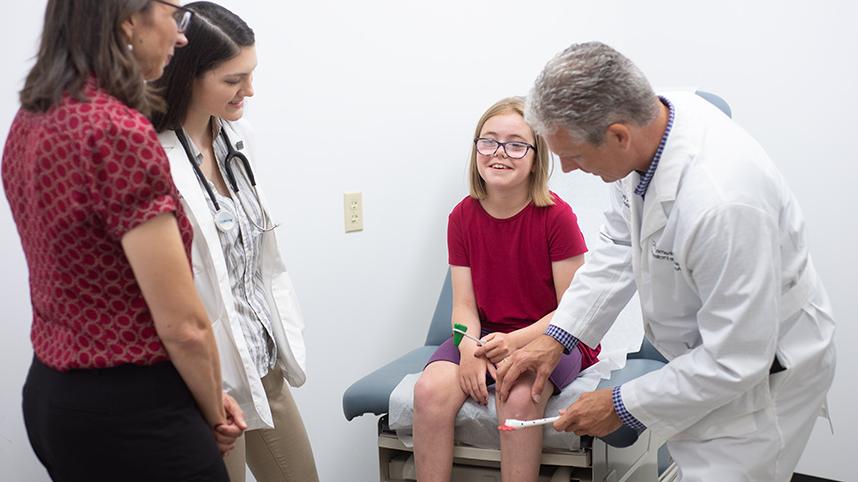 Jason Grahame, director of the PA program, a young patient, student Kyrie Baden, and medical director Dr. Misti Grimson